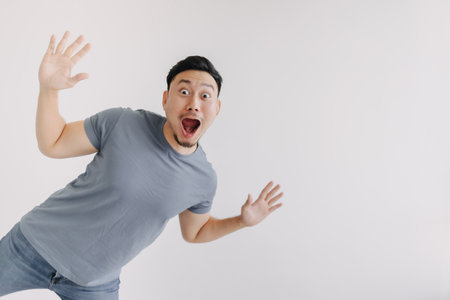 Wow face asian man full body jumping isolated on white. Shocked and surprised.の写真素材