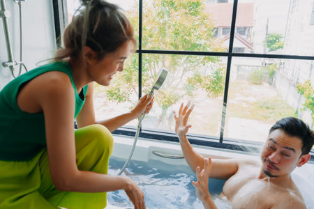 Funny playful asian couple lover play in a bathtub in the bathroom.の写真素材