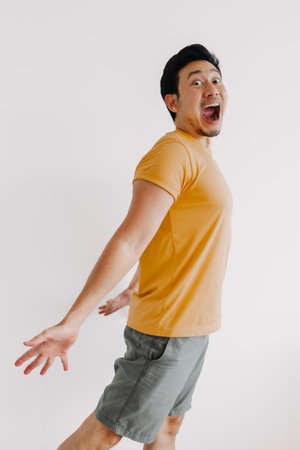 Vertical half body of funny wow face asian man jumping isolated on white.