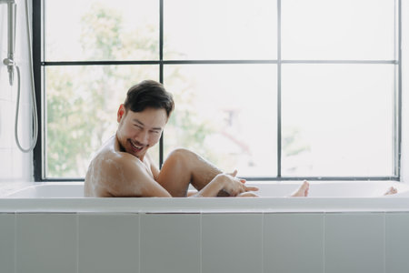 Funny hilarious expression of asian man in the bathtube try to be sexy.の写真素材