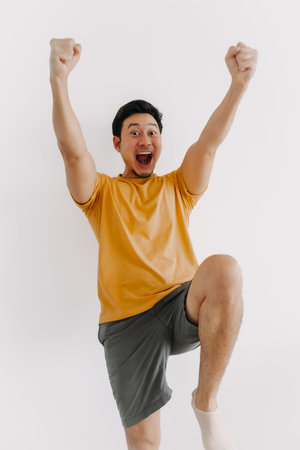 Vertical half body of funny wow face asian man jumping isolated on white.の写真素材