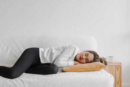 Happy asian woman taking a nap on the sofa on free empty day.の写真素材