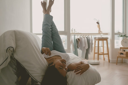 Asian woman lie on sofa in her apartment on free day weekends. Good vibes.の写真素材