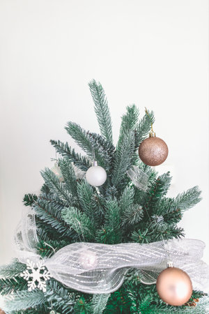 Decorated Christmas pine tree decorated with white gold ornaments and garlands isolated on white wall cerebrate for happy holiday and new yearの写真素材