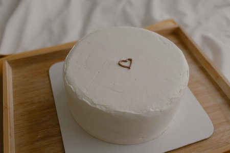 Closeup of minimal white cake with tiny heart for birthday or Valentine on the bed.の写真素材