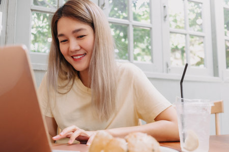 Happy asian woman working online on computer tablet in the cafe, Digital nomad.の写真素材