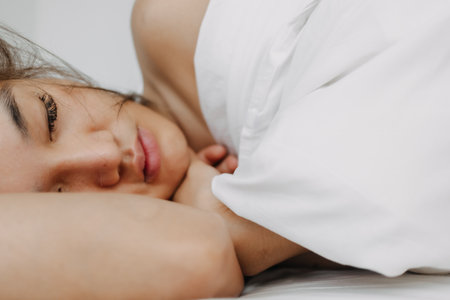Asian woman sleeping and wake up late in very comfort morning.の写真素材