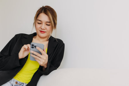 Happy and smile face asian woman using smartphone in white room.の写真素材