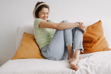 Happy asian woman in relaxed weekends day on sofa in the house.の写真素材