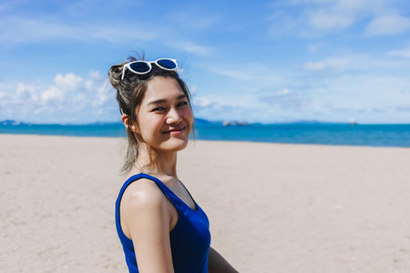 Happy smile asian woman in blue dress walking on the sunny beach of Pattaya.の写真素材