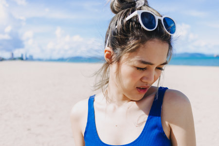 Asian woman fear bright sun at the beach in Pattaya, Thailand. Skincare concept.の写真素材
