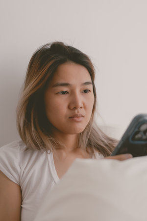 Asian woman feels sad and crying while checking the mobile phone.の写真素材