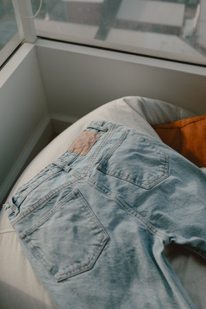 Blue Jean left drying on a relaxing beanbag with warm sunlight.の写真素材