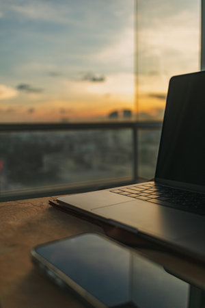 Computer laptop and mobile phone work set on wooden table in concept of home office freelance and...