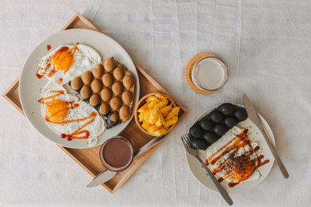Colorful breakfast set of waffles fried eggs and pineapple served in the morning.