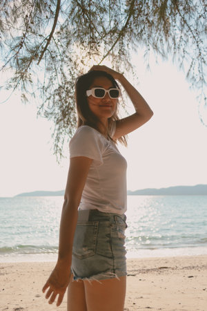 Cheerful Asian woman enjoy the breeze and walking on the beach in Thailandの写真素材