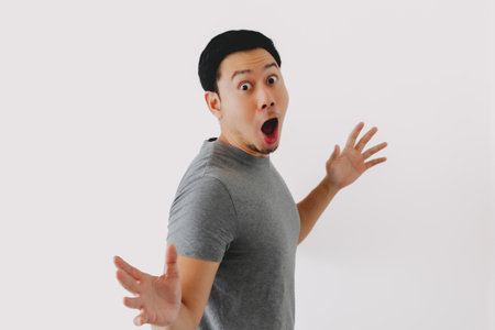 Wow and surprised face asian man in grey t-shirt isolated on white background.