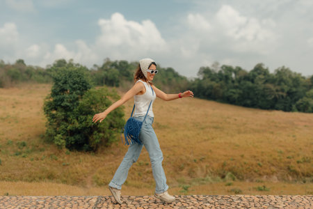 Cheerful asian woman walking for sightseeing the hills and fields of mountain.の写真素材