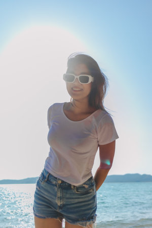 Happy asian woman enjoy taking photo on sunny beach. Thailand.の写真素材