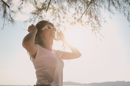 Cheerful Asian woman enjoy the breeze and walking on the beach in Thailandの写真素材