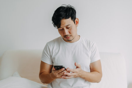 Sad asian man trying to call and connect to someone but no answer.の写真素材