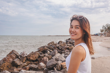 Aesthetic style of asian woman portrait relaxed on the windy beach.の写真素材