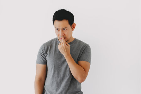 Sad and depressed humbly asian man in grey t-shirt isolated on white.の写真素材