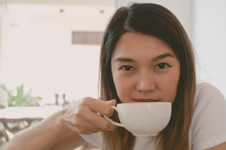 Asian woman is receiving a coffee cup and drink.