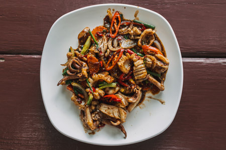 Thai Stir-fried squid with black pepper on white dish served on the table.の写真素材