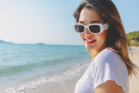 Close up of cheerful asian woman happy to be outdoor on the beach.の写真素材