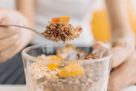 Happy asian woman eating healthy homemade snack made of yogurt.の写真素材