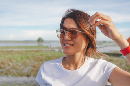 Asian woman enjoy the nature atmosphere of the lake.の写真素材