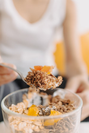 Happy asian woman eating healthy homemade snack made of yogurt.の写真素材