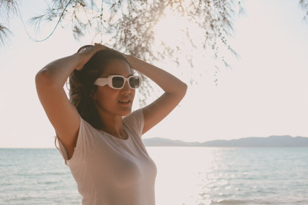Cheerful Asian woman enjoy the breeze and walking on the beach in Thailandの写真素材