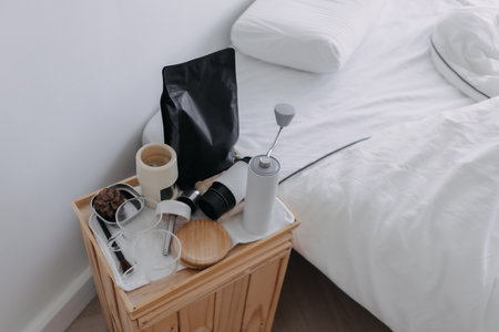 Set of espresso coffee making tools on the wooden board beside the white bed.の写真素材
