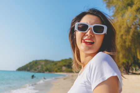 Close up of cheerful asian woman happy to be outdoor on the beach.の写真素材