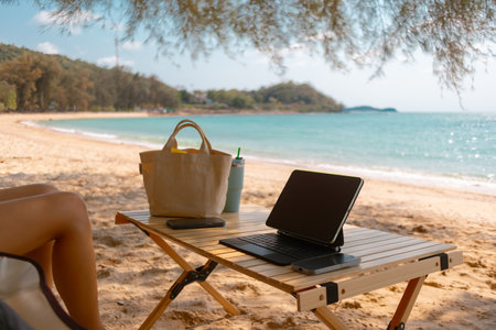 Concept of online freelance work and picnic outdoor on the beach with tablet.の写真素材