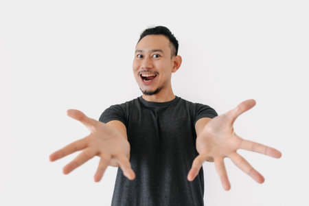 Happy Asian freelance man bun hair in black with thing in hand on white.