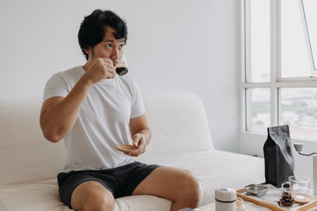 Asian man drinking espresso coffee that he just made for himself.の写真素材