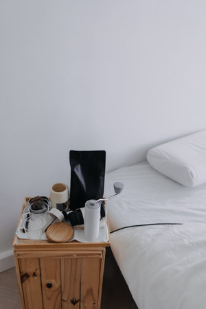 Set of espresso coffee making tools on the wooden board beside the white bed.の写真素材
