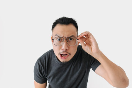 Serious angry face Asian freelance man bun hair in black on white.の写真素材