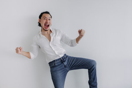 Winner face long hair Asian man bun in white shirt and jean stand on white.の写真素材