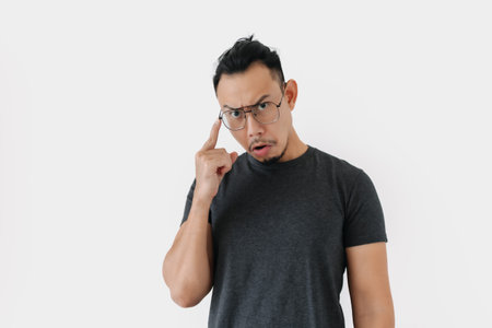 Serious angry face Asian freelance man bun hair in black on white.