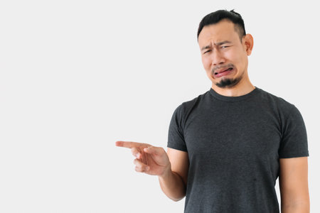 Sad crying Asian freelance man bun hair in black on white.の写真素材