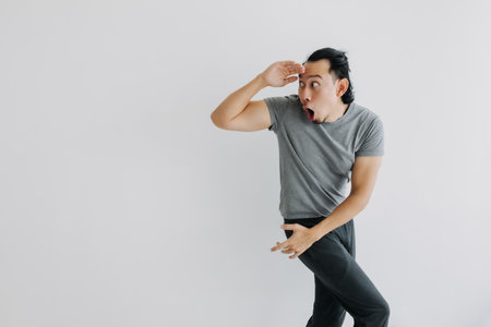 Unexpected surprise face Asian man walking and turn on isolated background. Full body.