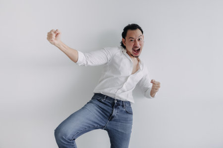 Winner face long hair Asian man bun in white shirt and jean stand on white.の写真素材