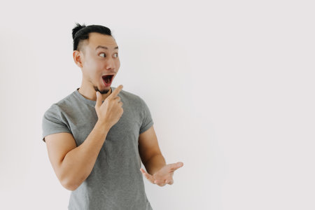 Wow and happy face of Asian man in grey t-shirt isolate on white.の写真素材