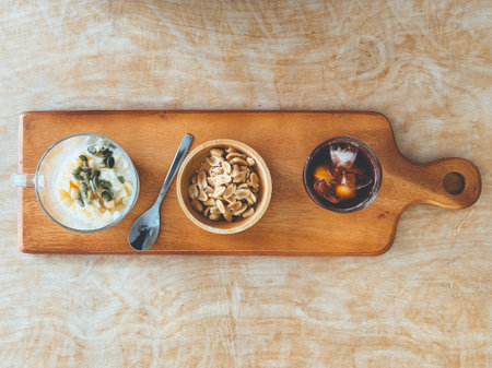 Healthy snack set of beans seeds yogurt and iced coffee on wooden plate.の写真素材