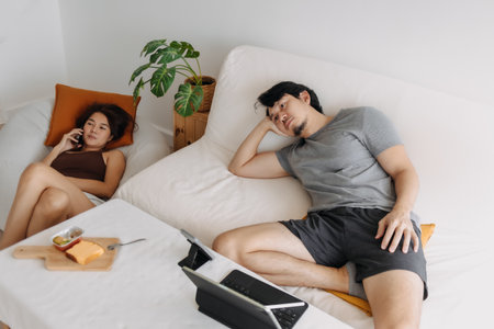 Asian couple lover, man tired of waiting woman having her phone call.の写真素材