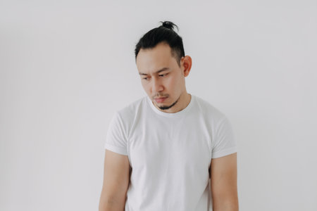 Shrug whatever face Asian man in white t-shirt isolate on white.の写真素材